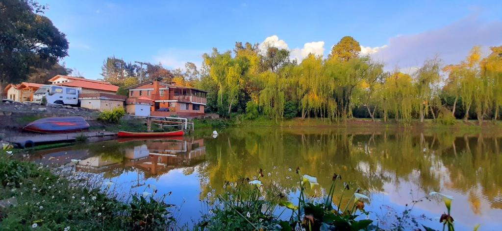 vistas a un lago con casas y árboles en Hacienda Moncora cabaña lago p2, en El Rosal