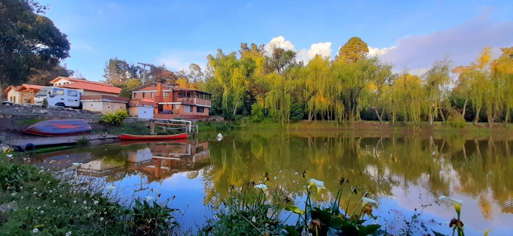 uma vista para um lago com casas e árvores em Hacienda Moncora cabaña lago p2 em El Rosal