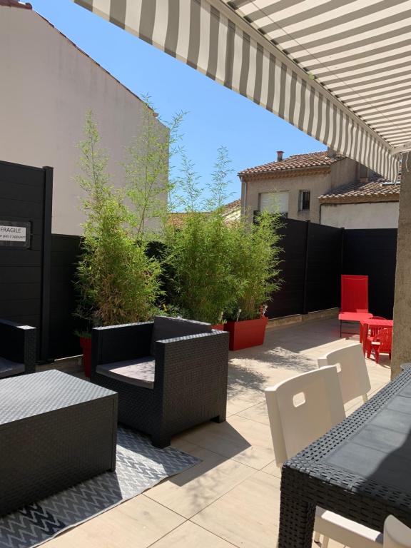 d'une terrasse avec des tables et des chaises et une clôture. dans l'établissement Appartement la corde a linge Gruissan village avec terrasses, à Gruissan