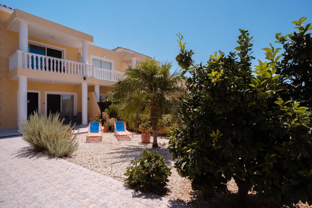 una casa con dos sillas azules delante de ella en Diana's Heights by Prestige Bookings, en Peyia