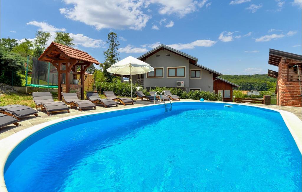 a swimming pool with chairs and a gazebo at Lovely Home In Jastrebarsko With Sauna in Jastrebarsko