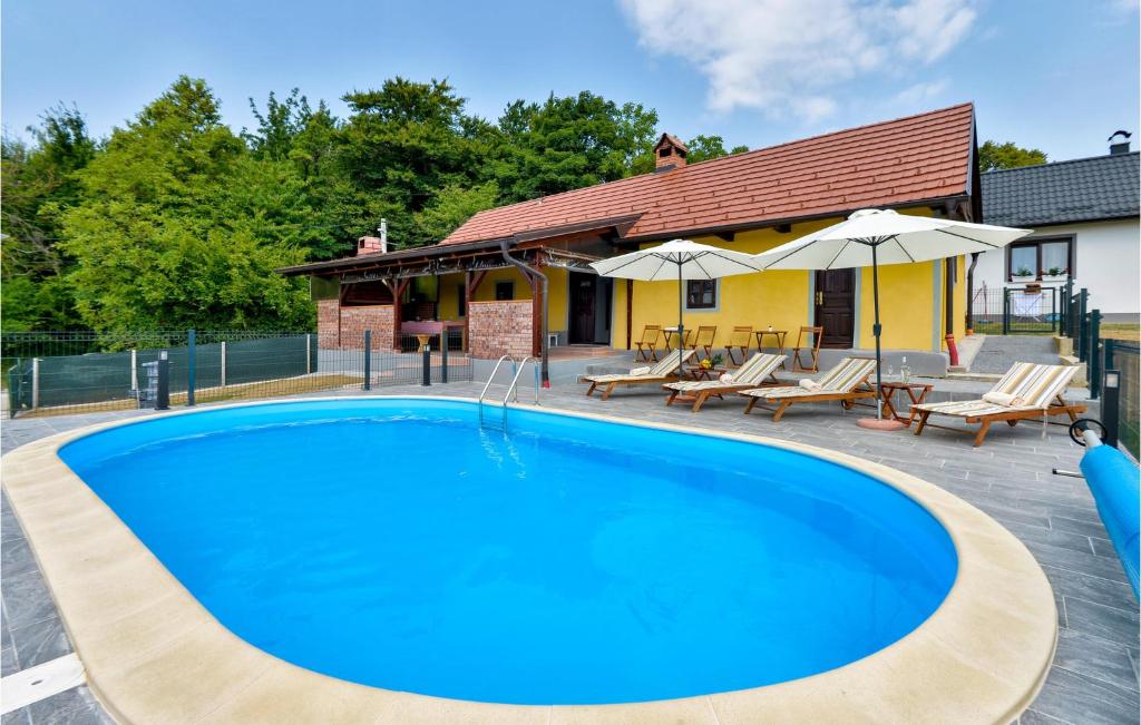 Cestica的住宿－Cozy Home In Cestica With Wifi，房屋旁的游泳池配有椅子和遮阳伞