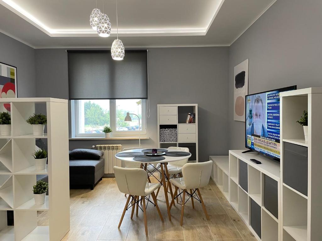 a living room with a table and chairs and a tv at Apartament BERLIN in Białystok
