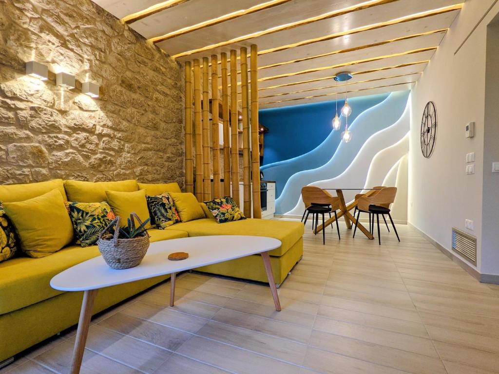 uma sala de estar com um sofá amarelo e uma mesa em Kotroni Villas em Finikounta