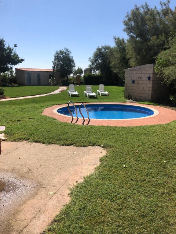 a swimming pool with two lounge chairs and a poolificialificialificialificialificialificial at Casa rural villa romero in Villacañas