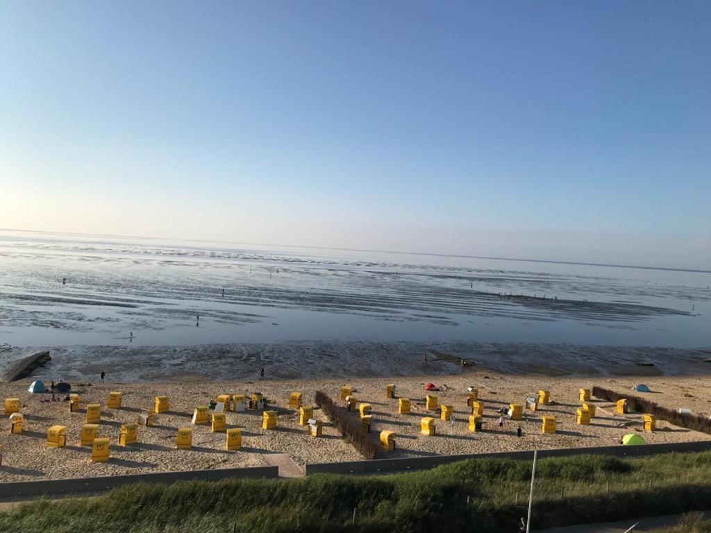 eine Gruppe von Stühlen am Strand in der Nähe des Wassers in der Unterkunft Silbermöwe - Traumhafter Meerblick in Cuxhaven