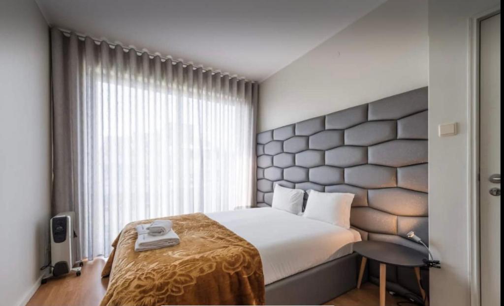 sypialnia z łóżkiem i dużym oknem w obiekcie Silver Duque w Porto