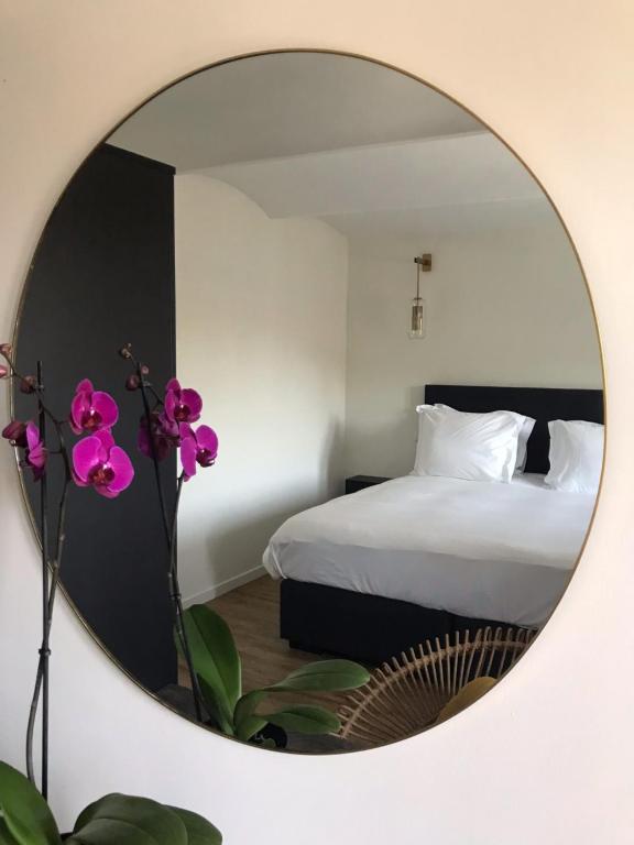 einen Spiegel in einem Schlafzimmer mit einem Bett in der Unterkunft Sotto La Vigna Charm Stay Adults only vacation Suite in Montegrosso dʼAsti