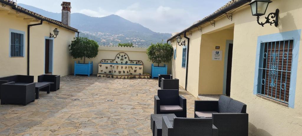 um pátio com cadeiras pretas num edifício em Casas Rurales- "Casa Larios" em El Colmenar