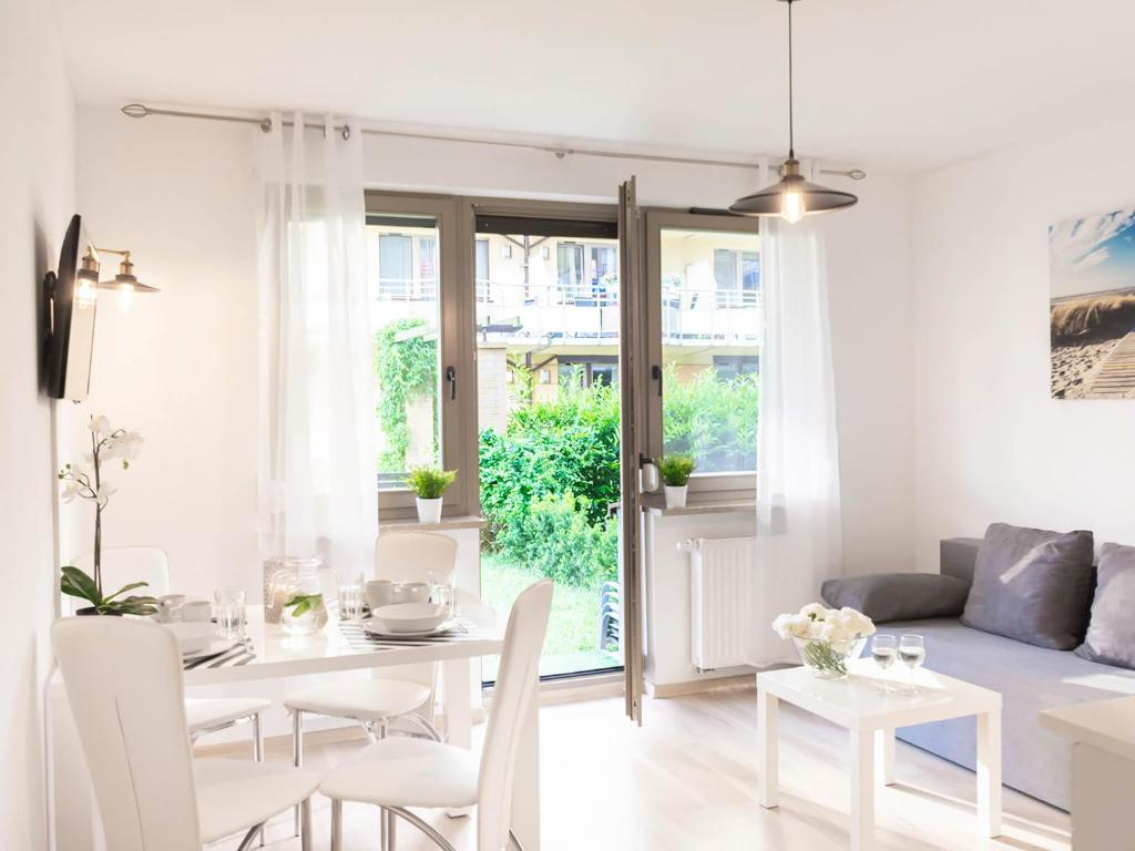 biały salon ze stołem i krzesłami w obiekcie VacationClub – Zdrojowa 22 Apartament 5 w Świnoujściu