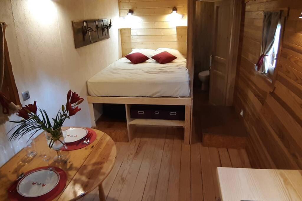 a small room with a bed and a table at Charmante Roulotte atypique in Jaujac