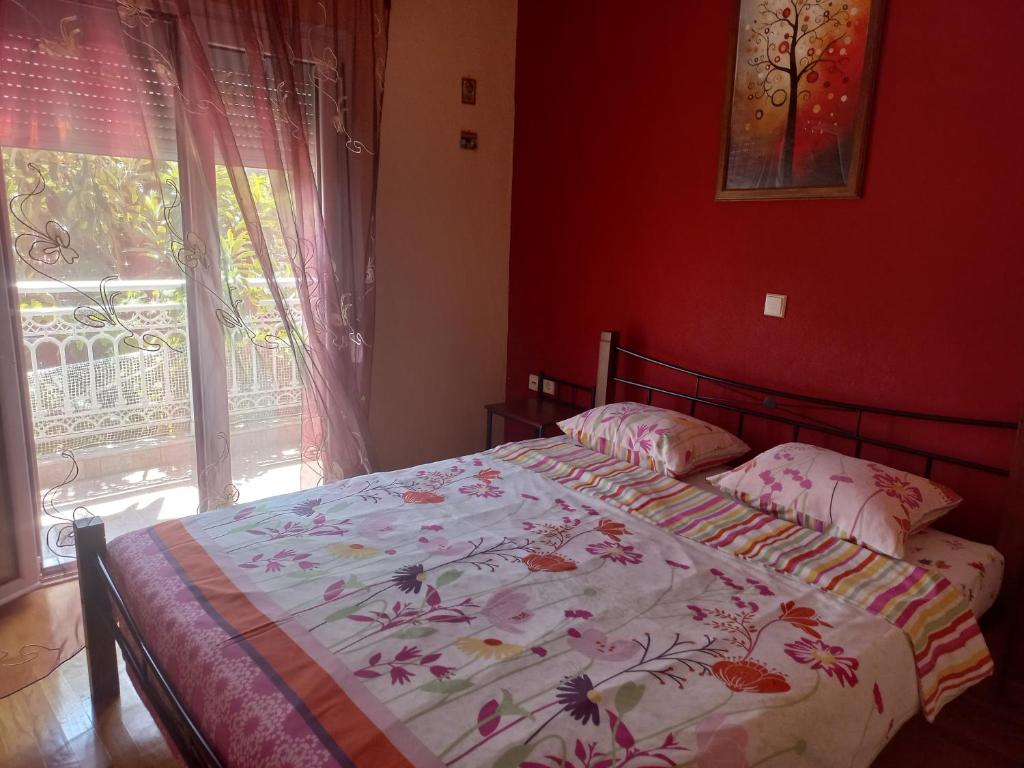 a bedroom with a bed with a floral bedspread and a window at Big apartment next to Olympus mountain in Litochoro