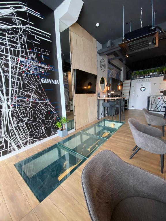 a lobby with a glass floor and a drawing on the wall at Thruster - mini kino, lobby, kuchnia, netflix in Gdynia