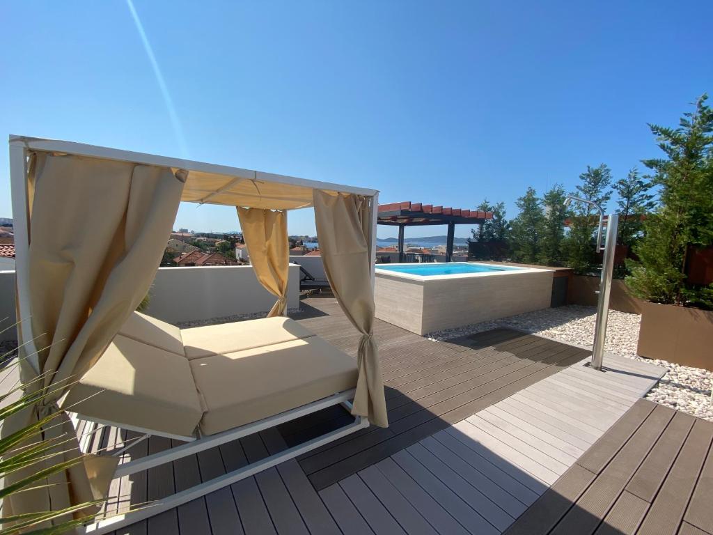 a patio with a hammock and a swimming pool at Shell Sky Luxury Penthouse with Private Pool in Zadar