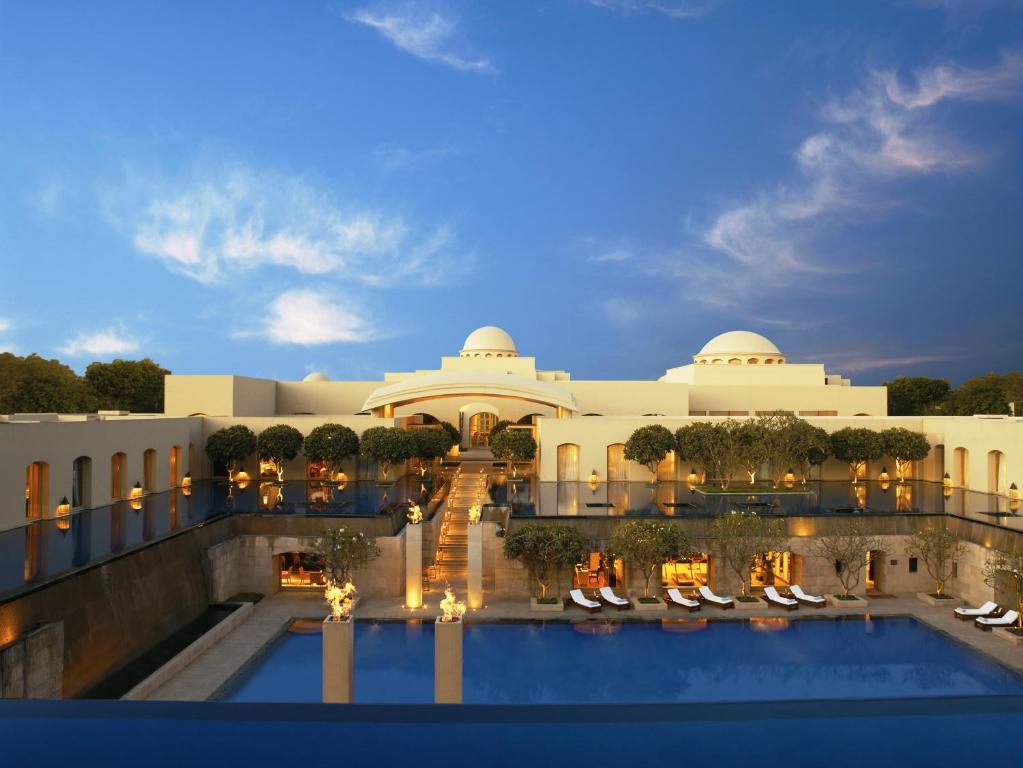 a hotel with a pool in front of a building at Trident Gurgaon in Gurgaon