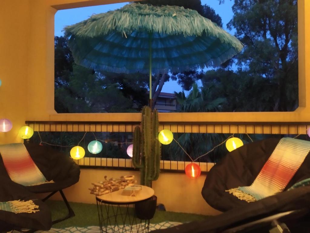 - une terrasse avec une table et un grand parasol dans l'établissement Studio Paradise entre mer et pins, à Saint-Raphaël