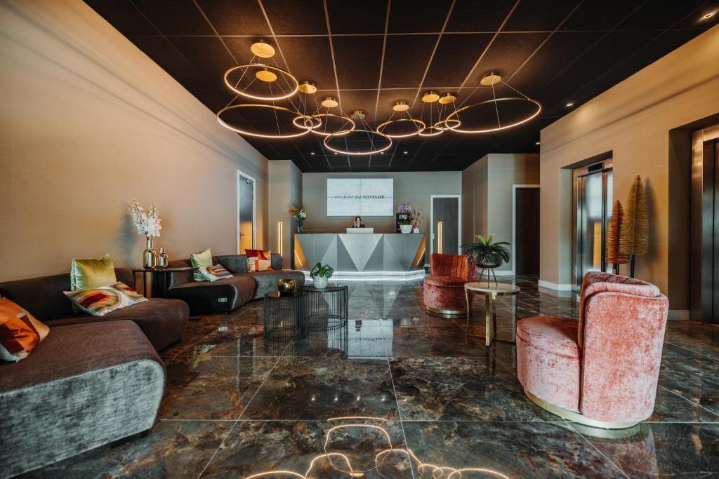 a large living room with couches and a chandelier at HOTELUX Amsterdam Airport Hotel in Hoofddorp