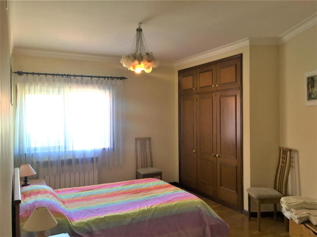 um quarto com uma cama e uma janela em Alojamento Rocha em Viseu