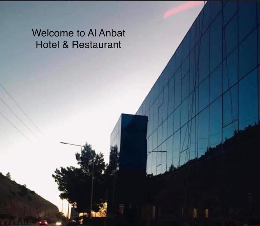 un edificio de cristal con las palabras bienvenidos a un hotel y restaurante del aeropuerto en Al Anbat Hotel & Restaurant, en Wadi Musa