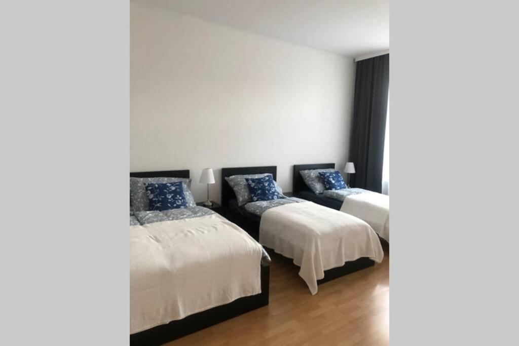 2 Betten in einem Zimmer mit weißen Wänden und Holzböden in der Unterkunft Wohnung in Wien in Wien