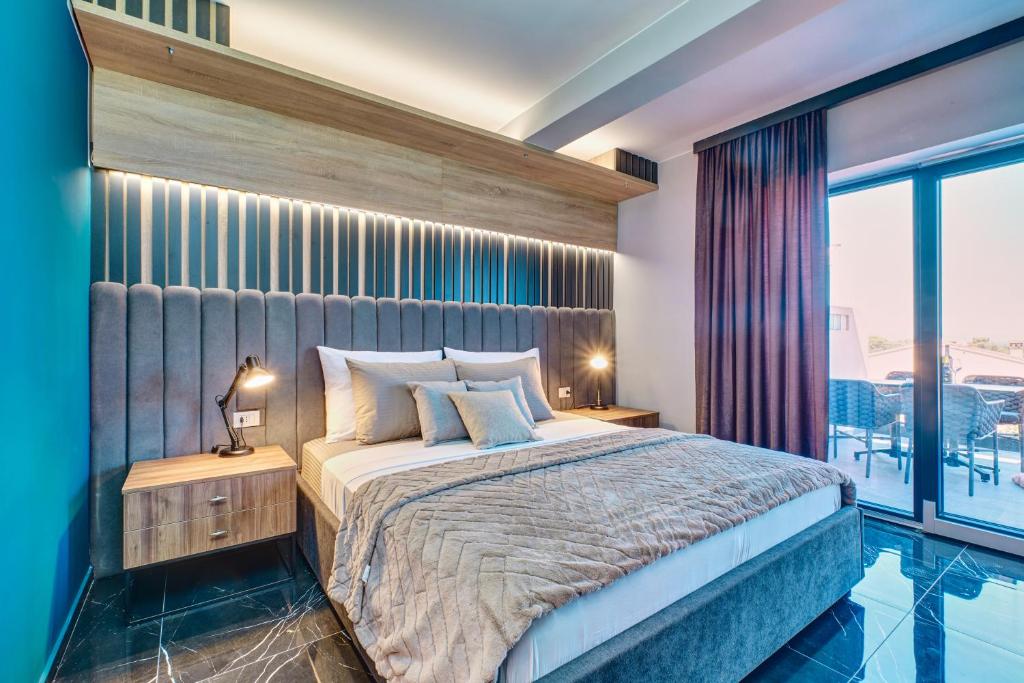 a bedroom with a bed and a large window at Luxury apartments in Mali Lošinj