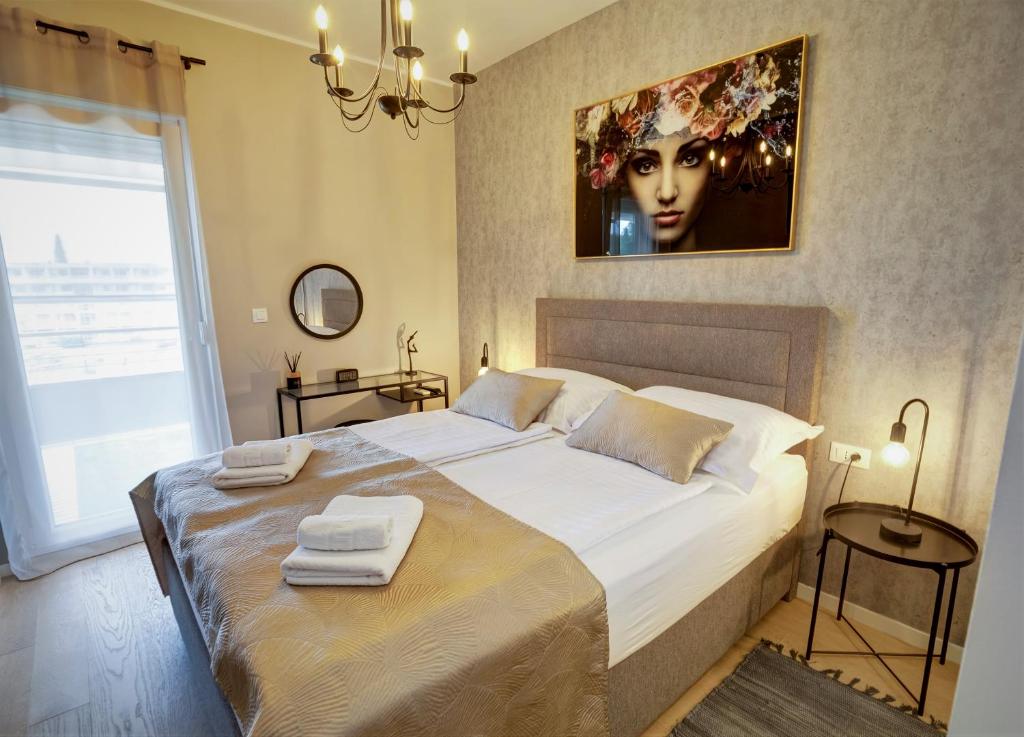 een slaapkamer met een groot bed en handdoeken bij Luxury Apartment 4Seasons with Garage in Split
