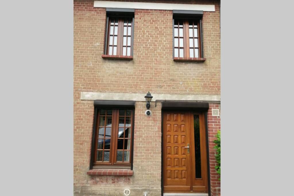 a brick house with brown doors and windows at Escapade Normande in Yerville