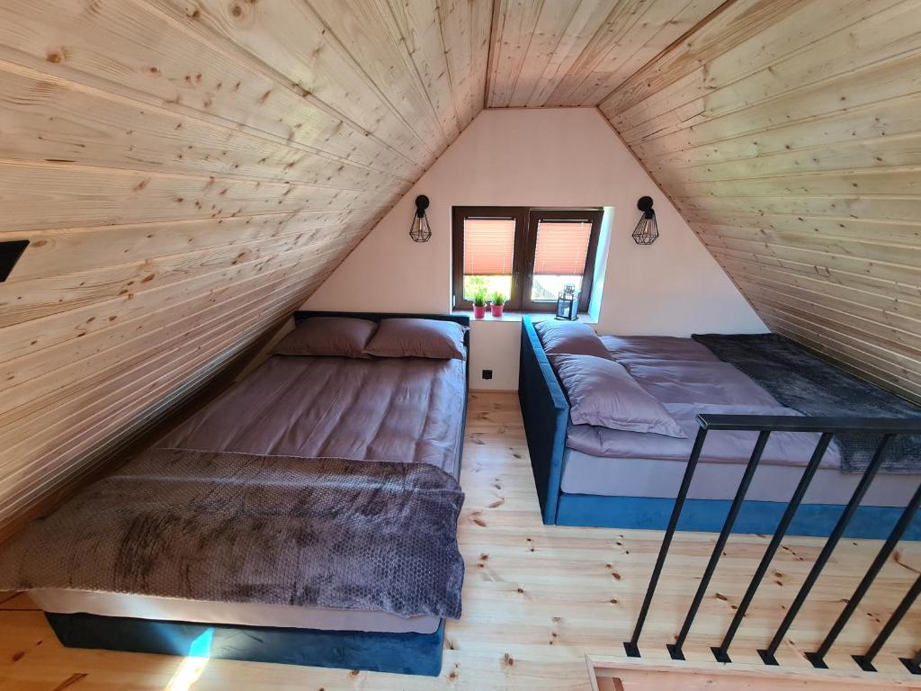 KaliskaにあるOstoja Relaksu Cieciorkaの小さな家のベッド2台付きの部屋