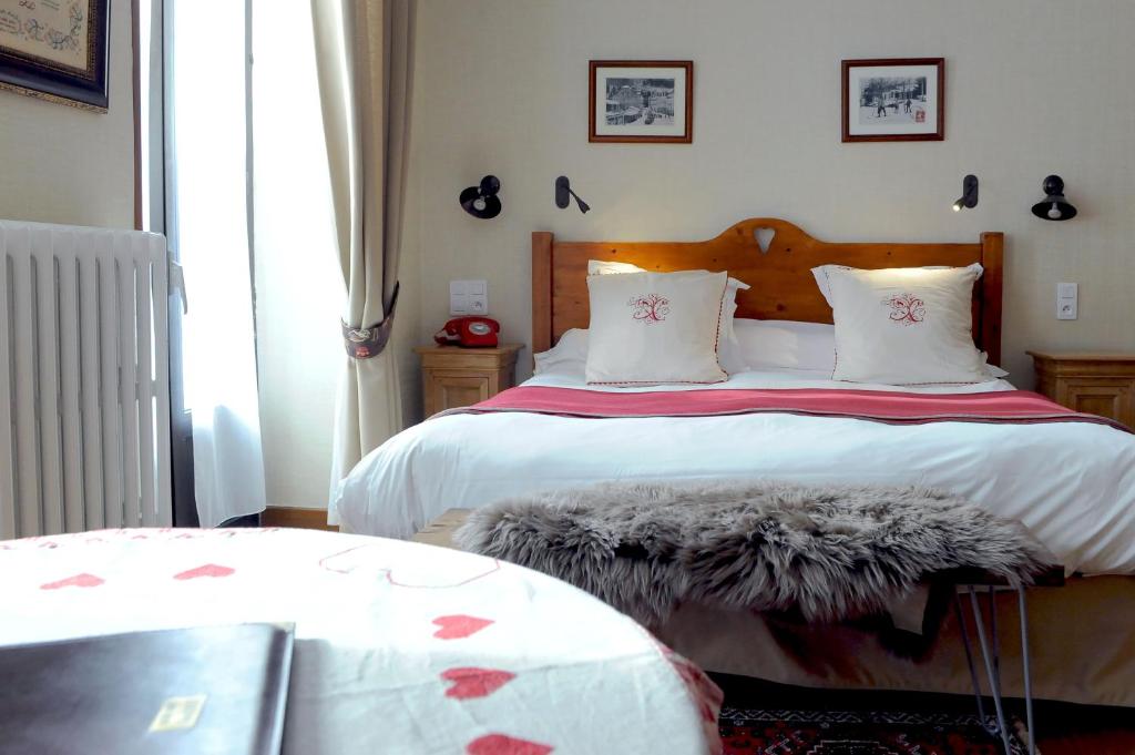 a bedroom with a large bed with a large window at Hôtel du Lion d'Or in Cauterets