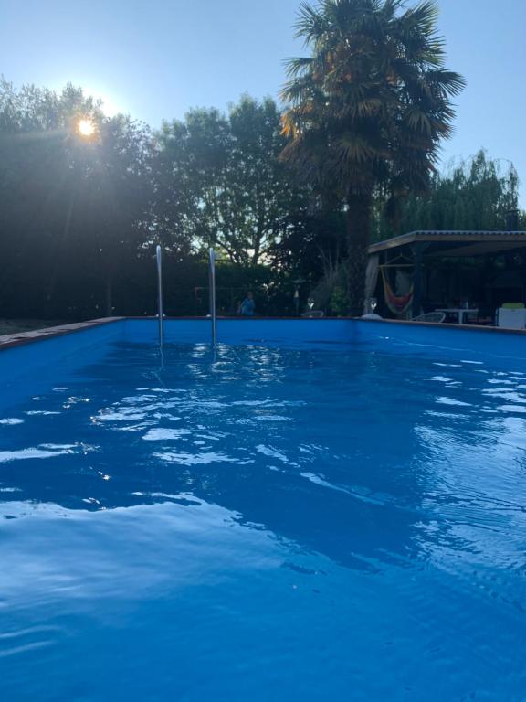 une grande piscine d'eau bleue dans l'établissement Chambres des marais, à Merville-Franceville-Plage