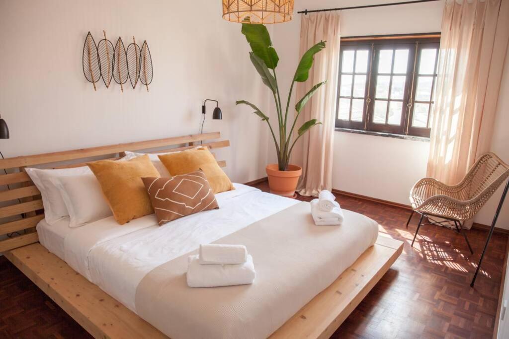 a bedroom with a large white bed with pillows at Kodu Lodge - spacious 2 storey coastal home with balcony, sea view, garden & BBQ in Santo Isidoro