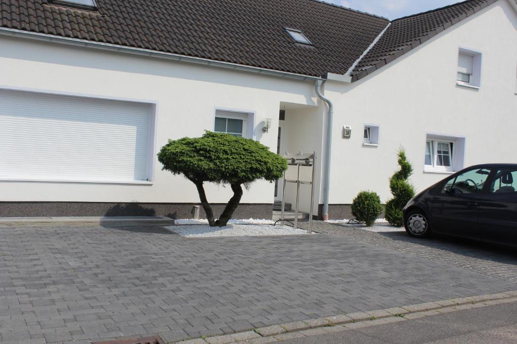 um carro estacionado em frente a uma casa com uma árvore em Zimmer David em Colônia