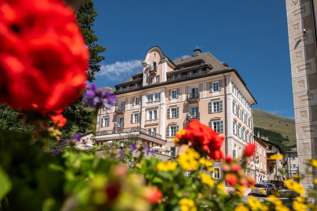 ein großes Gebäude mit Blumen davor in der Unterkunft Hotel Engiadina in Zuoz