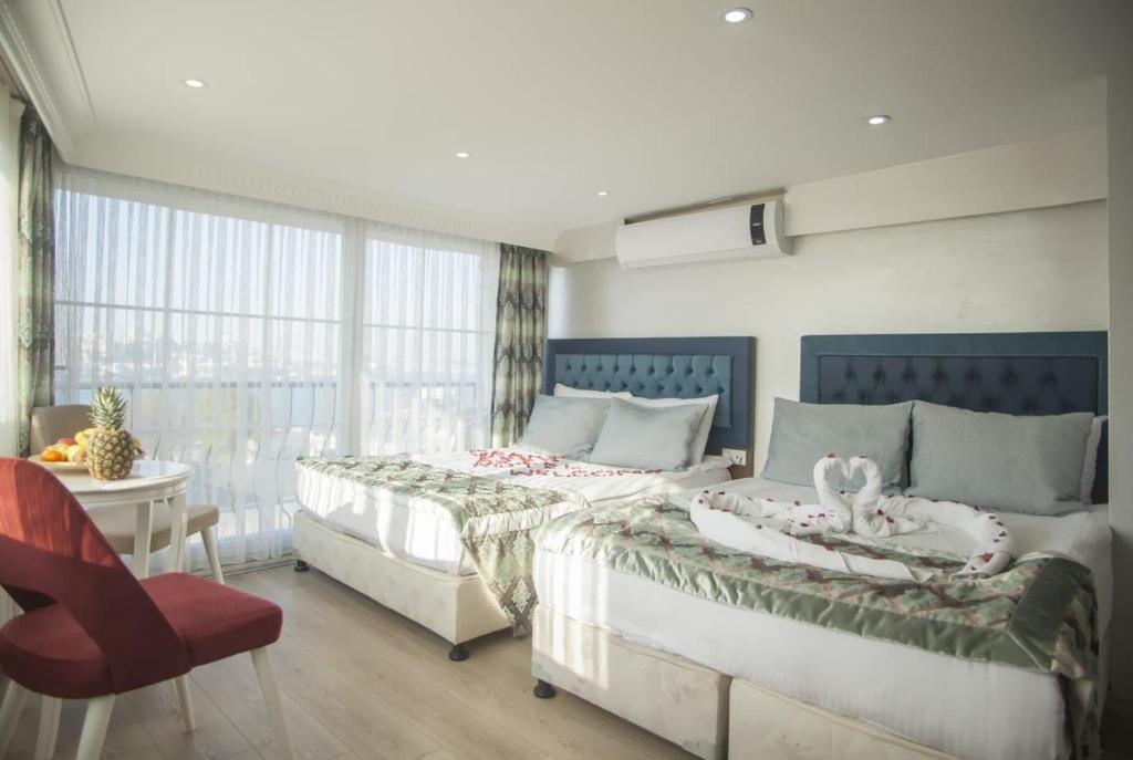 1 Schlafzimmer mit 2 Betten und einem roten Stuhl in der Unterkunft Grand Esen Boutique Hotel in Istanbul