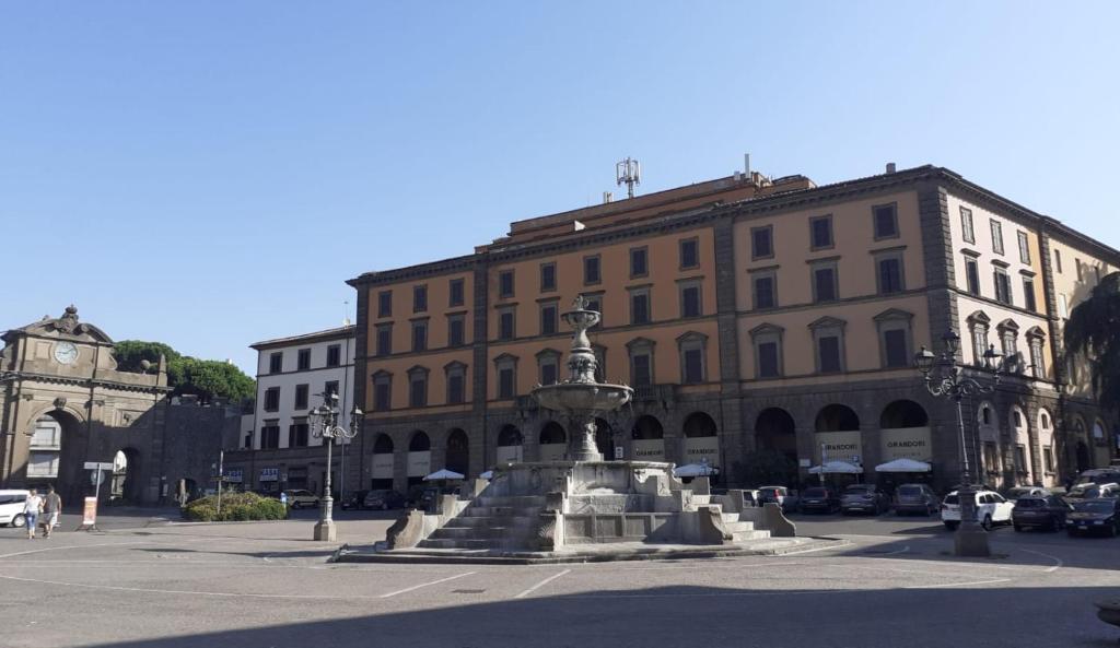 a fountain in a street in front of a building at Palazzo Grandori Alloggi Turistici in Viterbo