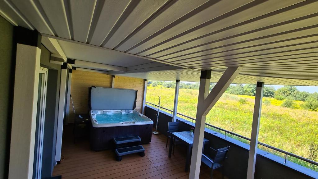 a screened porch with a hot tub and a view of a field at Apartament - Jacuzzi in Rzeszów