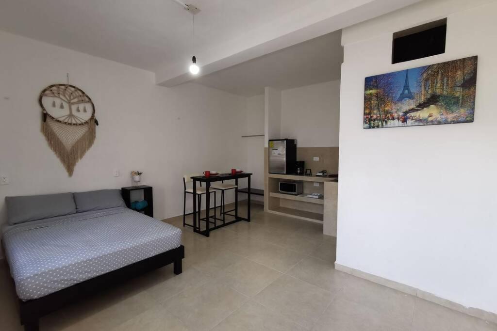 ein Wohnzimmer mit einem Bett und eine Küche in der Unterkunft Casa en Mahahual cerca de la playa D1 in Mahahual