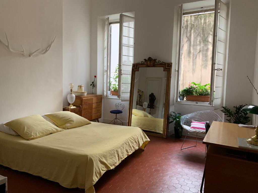 - une chambre avec un lit et un miroir dans l'établissement Liberté, à Marseille
