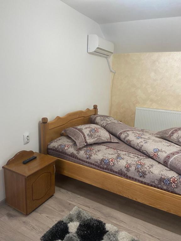 1 dormitorio con 2 camas y mesita de noche en Pensiunea Casa Deny, en Novaci-Străini