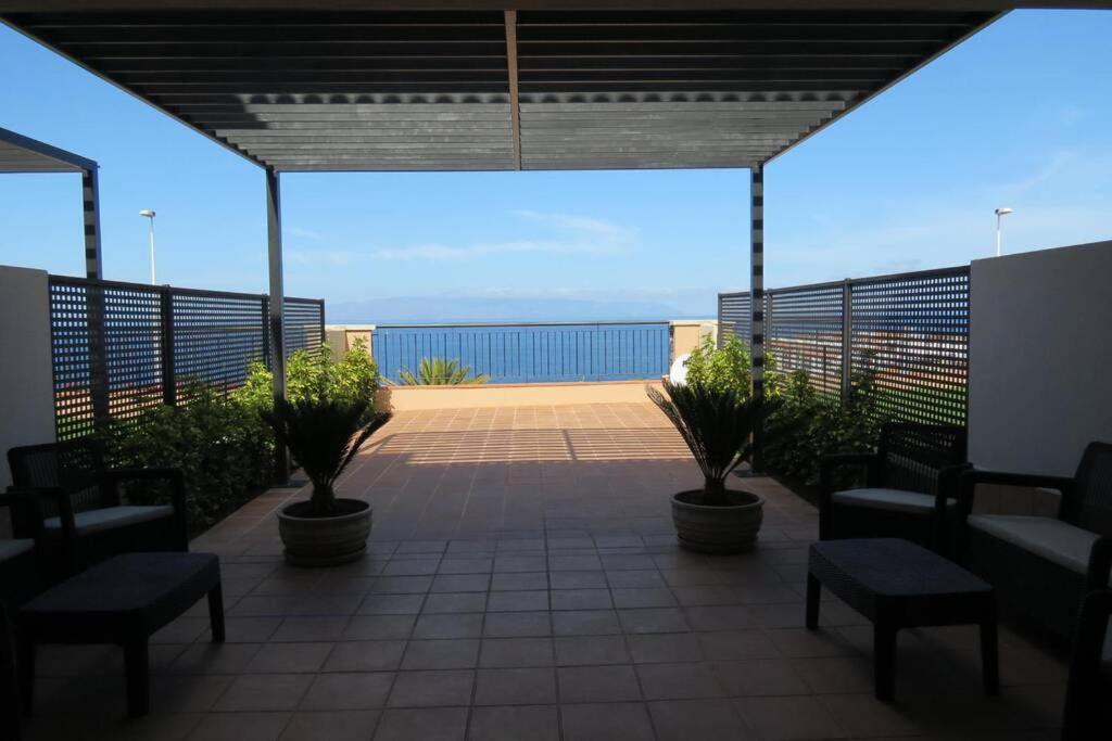 eine Terrasse mit Stühlen und Blick auf das Meer in der Unterkunft Luxury House with 3 Bedrooms, Sea Wiew and Swimming Pool in a quiet Residence in Puerto de Santiago