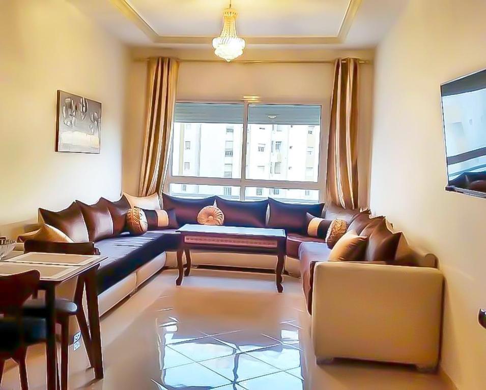 een woonkamer met een bank en een tafel bij Apartment Borj Rayhane in Tanger