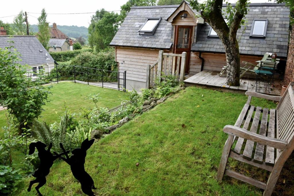 een zwarte hond rennend in een tuin naast een huis bij The Roost in Semley