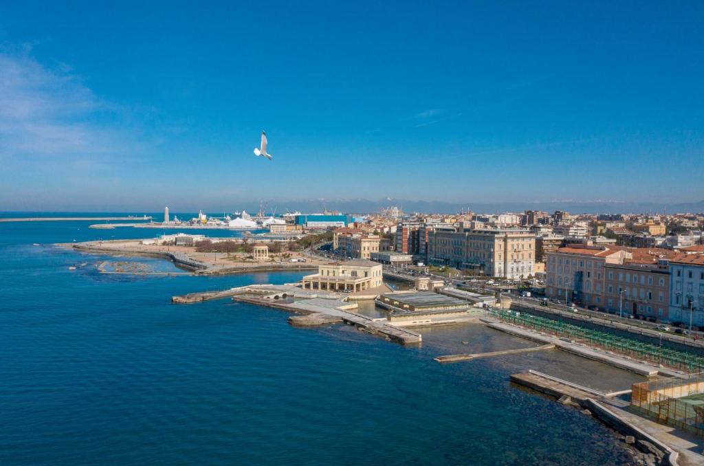 una vista aérea de una ciudad con un avión volando sobre el agua en CASAMIELI, Nuovo, vicino al porto al mare e al centro, en Livorno