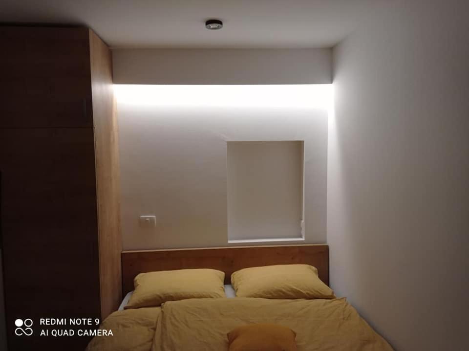sypialnia z łóżkiem z lampką powyżej w obiekcie Apartma Aurora w mieście Kranjska Gora