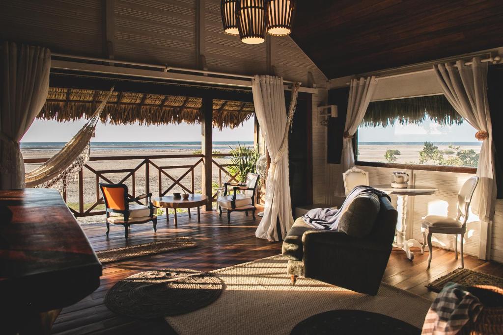 a living room with a view of the beach at Kitejuba Bungalows in Tatajuba