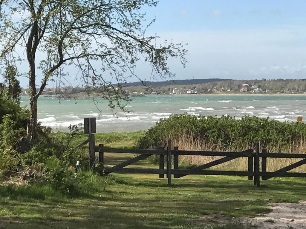 a wooden fence in front of a body of water at Sjöstugan Vallersvik in Frillesås