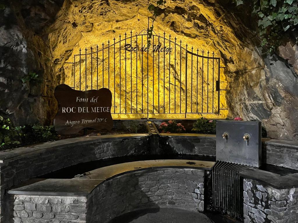eine steinerne Bank in einer Höhle mit einem Schild in der Unterkunft Alberg Els Andes in Andorra la Vella