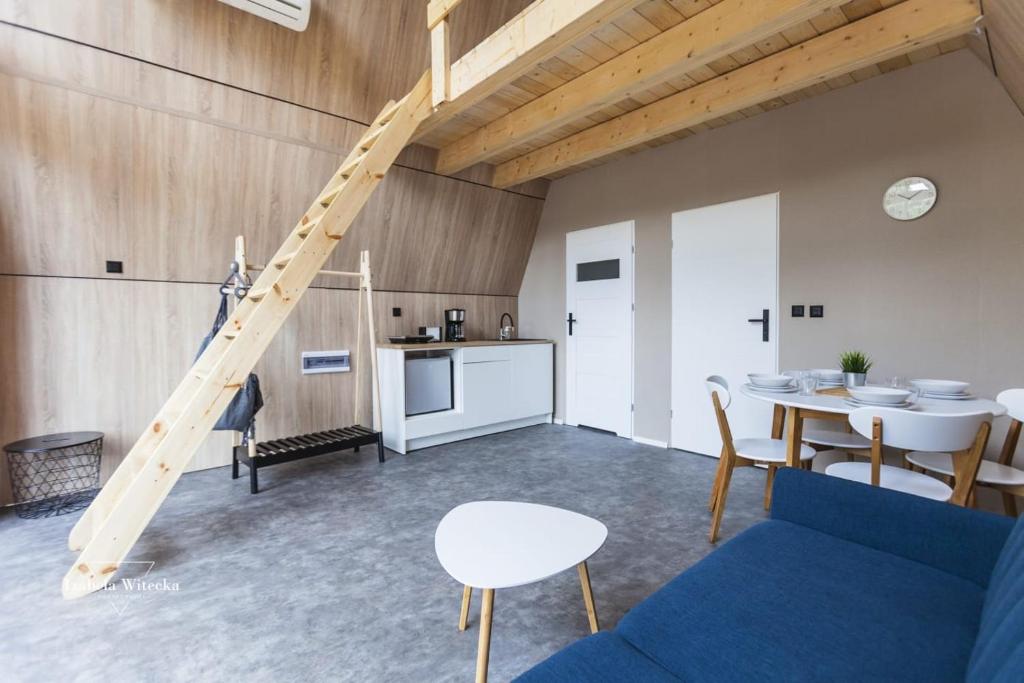 a living room with a blue couch and a table at Domki RWL in Rewal