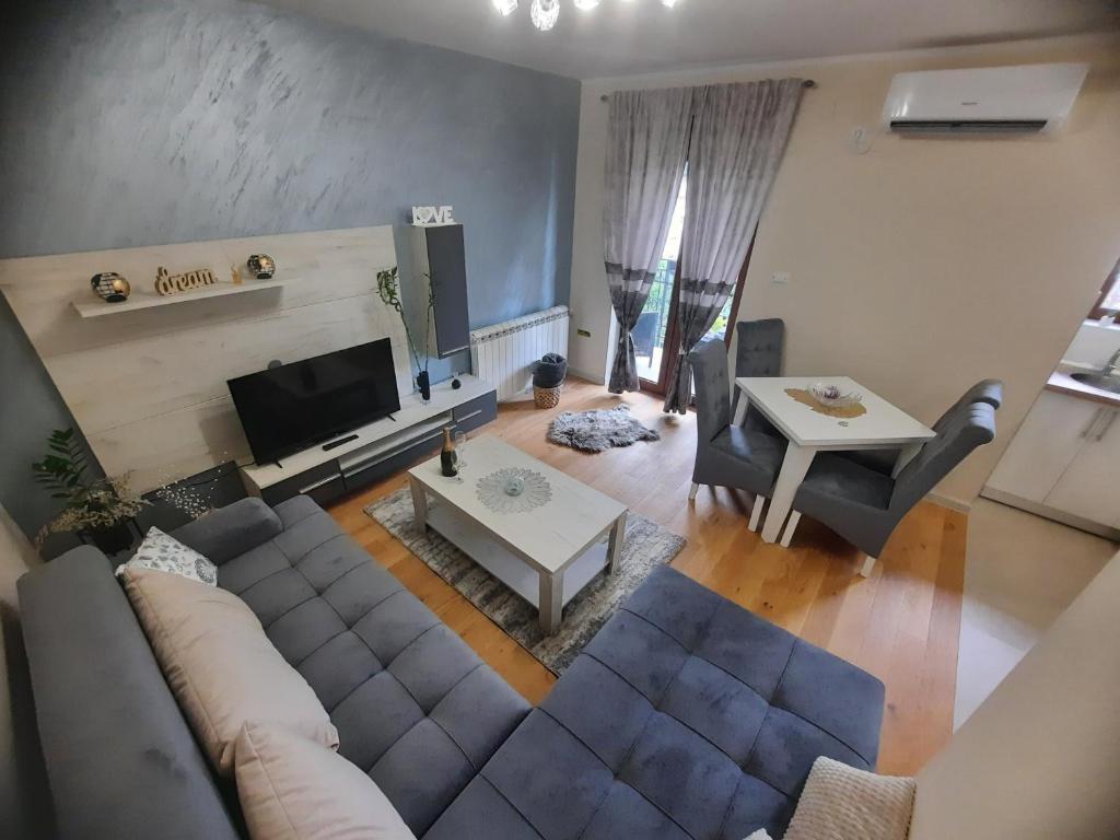 uma vista superior de uma sala de estar com um sofá e uma mesa em Apartman Korićanac Vrnjačka Banja em Vrnjačka Banja