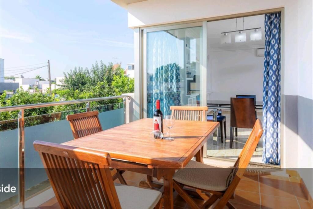 einen Holztisch und Stühle auf dem Balkon in der Unterkunft Syrenah Apartment in Can Picafort in Can Picafort